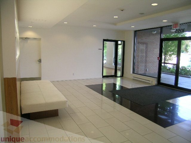 Furnished living room with white walls, tiled floor, and glass doors leading outside. - 705 - 1055 Homer Street, Vancouver Downtown