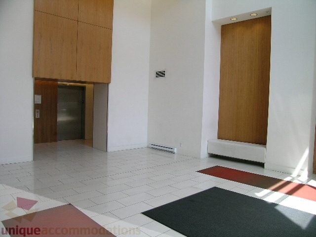 Furnished living room with white walls, wooden accents, and a tiled floor. - 705 - 1055 Homer Street, Vancouver Downtown