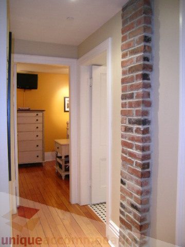 Furnished living room with hardwood floors and brick accent wall. - 1211 Nelson Street, Vancouver Downtown