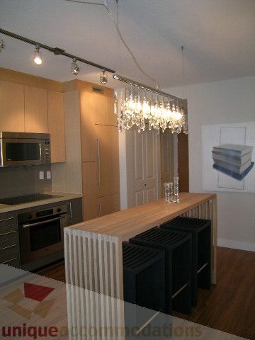 Bright kitchen with modern island, hardwood floors, and a chandelier. - 208 - 1833 Crowe St., Vancouver West Side