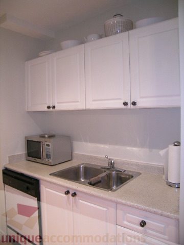 Bright kitchen with white cabinets, granite countertops, and a stainless steel sink. - 405 - 233 Abbott Street, Vancouver Downtown