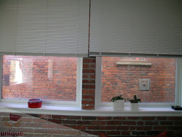 Bright kitchen with brick wall, white blinds, and potted plants on windowsill. - 405 - 233 Abbott Street, Vancouver Downtown
