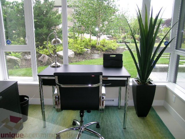Bright sunroom with large windows, greenery outside, and modern furniture. - 102 - 1333 West 11th Ave., Vancouver West Side