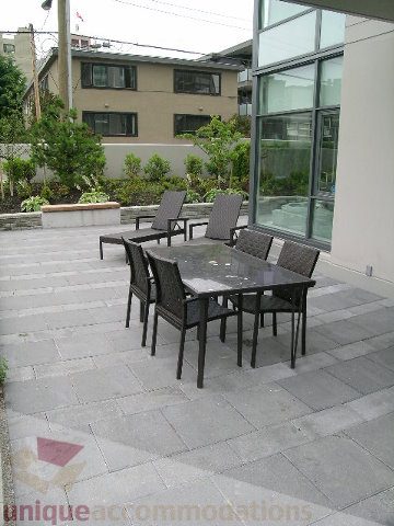 Furnished patio with outdoor seating and modern glass walls. - 102 - 1333 West 11th Ave., Vancouver West Side