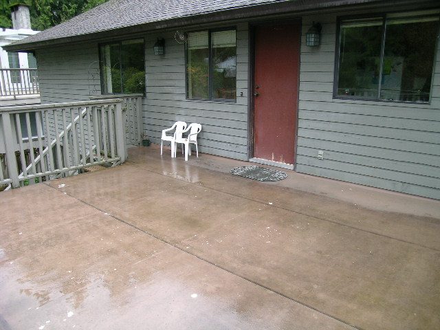 Spacious patio with wet concrete and wooden railings, perfect for outdoor relaxation. - 2203 West Keith Road, North Vancouver