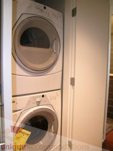 Bright laundry room with stacked washer and dryer, modern design. - 1209 - 1055 Richards Street, Vancouver Downtown