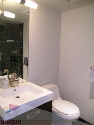 Modern bathroom with sleek white fixtures and a minimalist design. - 1209 - 1055 Richards Street, Vancouver Downtown
