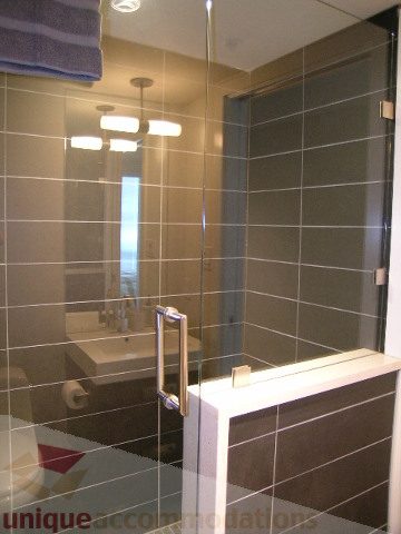 Modern bathroom with sleek tile countertops and a large mirror. - 1209 - 1055 Richards Street, Vancouver Downtown