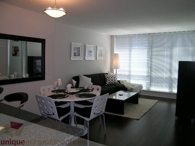 Spacious living room with modern furniture, large windows, and a cozy ambiance. - 1209 - 1055 Richards Street, Vancouver Downtown