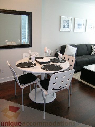 Modern dining area with white chairs, black and white table, and dark hardwood floors. - 1209 - 1055 Richards Street, Vancouver Downtown