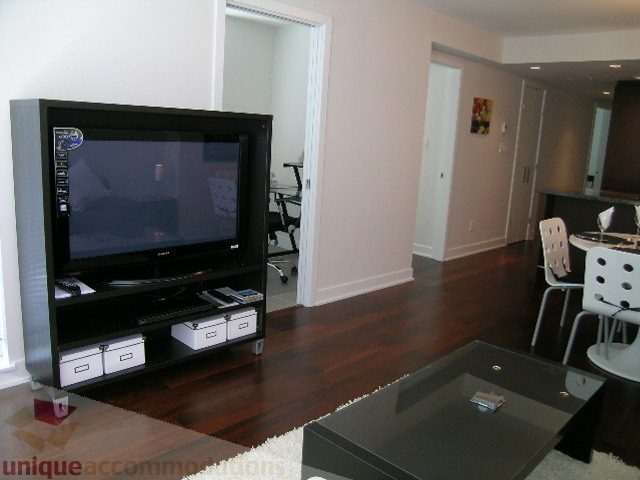 Modern living room with hardwood floors, black entertainment unit, and sleek coffee table. - 1209 - 1055 Richards Street, Vancouver Downtown