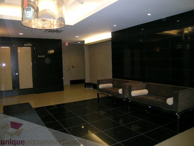 Spacious lounge area with sleek black tiles and modern furniture, perfect for relaxation. - 1209 - 1055 Richards Street, Vancouver Downtown
