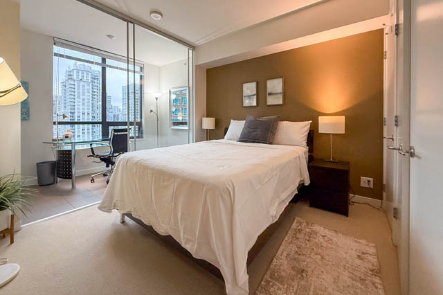 Spacious 1-bedroom + den condo with a cozy bed, city view, and modern furnishings. - 1802 - 788 Richards, Vancouver Downtown