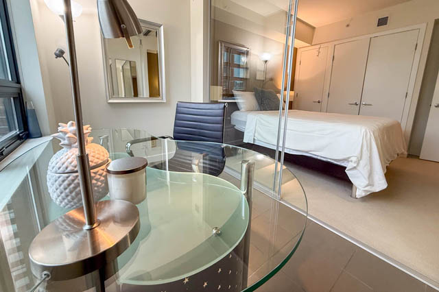 Modern 1-bedroom + den condo with sleek glass table and contemporary decor. - 1802 - 788 Richards, Vancouver Downtown