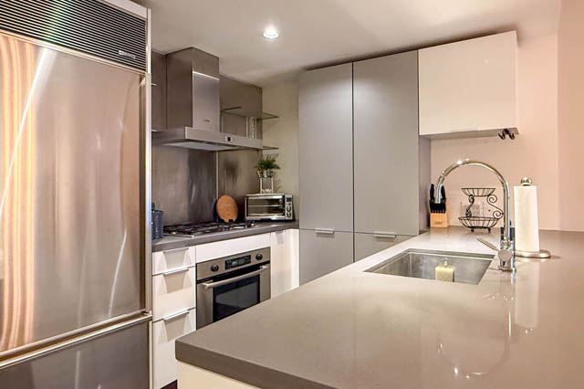 Bright kitchen with sleek stainless steel appliances, modern countertops, and a spacious island. - 1802 - 788 Richards, Vancouver Downtown