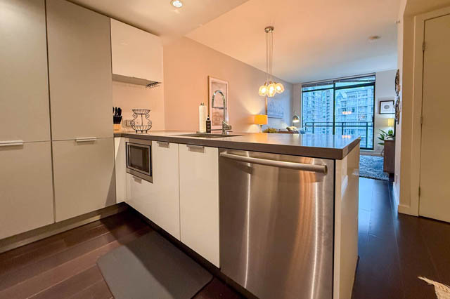 Bright kitchen with stainless steel appliances, hardwood floors, and a city view. - 1802 - 788 Richards, Vancouver Downtown