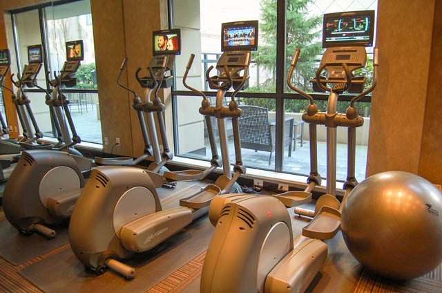 Bright gym with elliptical trainers and large windows offering a city view. - 1802 - 788 Richards, Vancouver Downtown