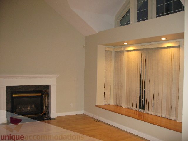 Spacious living room with high ceilings, hardwood floors, and a cozy fireplace. - 2737 Mahon Ave., North Vancouver