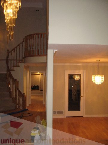 Staircase leading to second floor with chandelier and hardwood floors. - 2737 Mahon Ave., North Vancouver