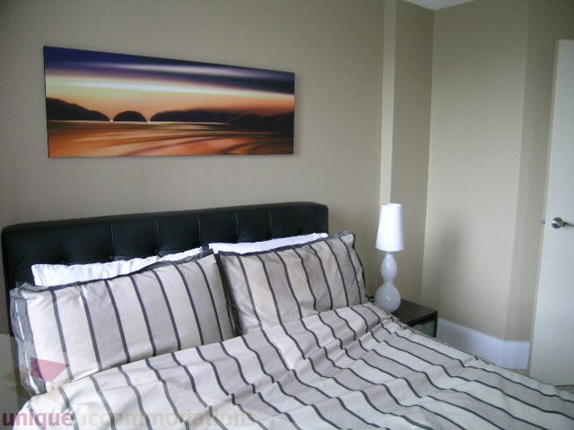 Furnished bedroom with striped bedding and abstract art above the bed. - 2005 - 388 Drake Street - Governors Tower, Vancouver Downtown
