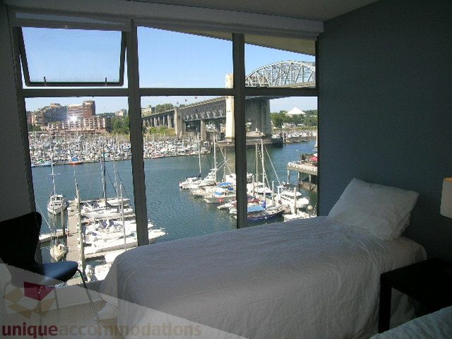 Furnished bedroom with city view and marina, overlooking boats and bridge. - 310 - 990 Beach, Vancouver Downtown