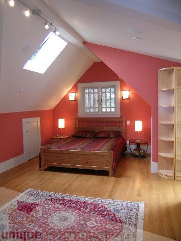 Bright loft bedroom with wooden floors, skylight, and red accent wall. - 4035 West 27th Avenue, Vancouver West Side
