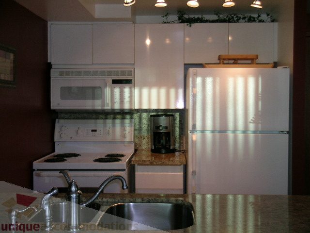 Bright kitchen with granite countertops and white cabinetry, modern appliances. - 1403 - 555 Jervis Street, Vancouver Downtown