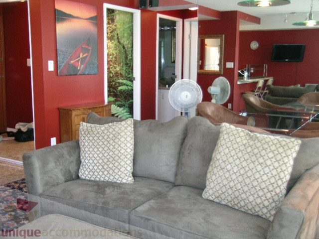 Furnished living room with gray couch, red walls, and ceiling fans. - 1403 - 555 Jervis Street, Vancouver Downtown
