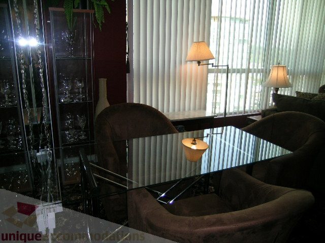 Living room with glass coffee table, brown armchairs, and vertical blinds. - 1403 - 555 Jervis Street, Vancouver Downtown