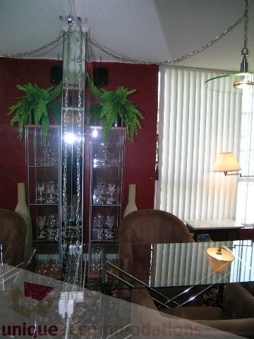 Furnished living room with glass coffee table, red walls, and vertical blinds. - 1403 - 555 Jervis Street, Vancouver Downtown