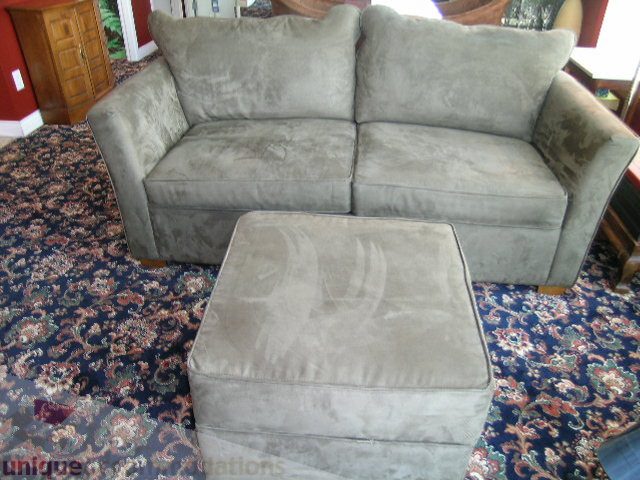 Living room with plush gray couch and matching ottoman on patterned rug. - 1403 - 555 Jervis Street, Vancouver Downtown
