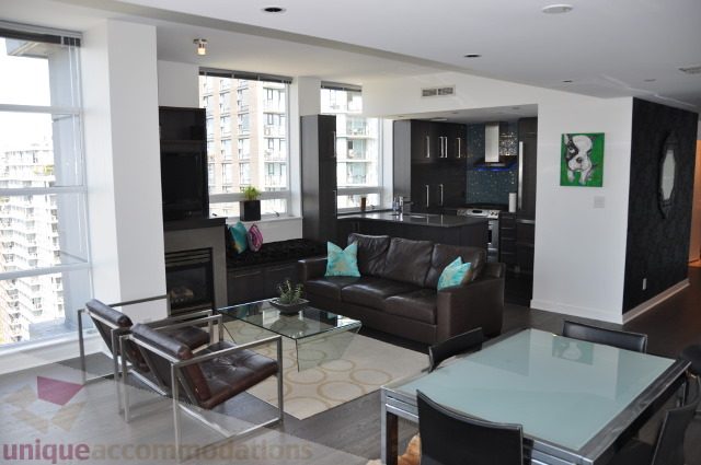 Furnished living room with city view, modern furniture, and dark wood accents. - 2702 - 638 Beach Crescent, Vancouver Downtown