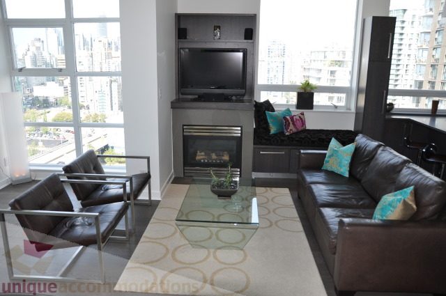 Furnished living room with city view, modern furniture, and a fireplace. - 2702 - 638 Beach Crescent, Vancouver Downtown