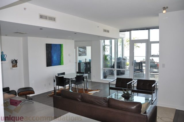 Furnished living room with modern furniture, large windows, and city view. - 2702 - 638 Beach Crescent, Vancouver Downtown