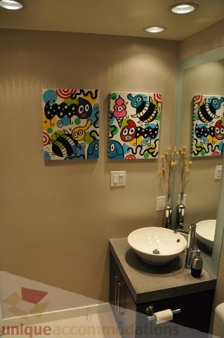 Bathroom with colorful monster art on walls, modern sink, and granite countertop. - 2702 - 638 Beach Crescent, Vancouver Downtown