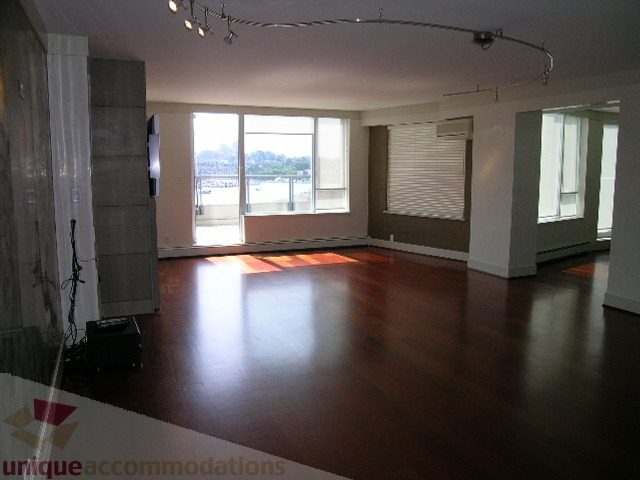 Spacious living room with hardwood floors, city view, and modern lighting. - 603 - 1383 Marinaside Crescent, Vancouver Downtown
