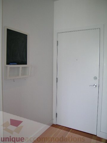Furnished bedroom with hardwood floors and a white door. - 902 - 528 Beatty Street, Vancouver Downtown