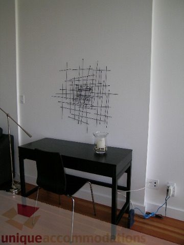 Furnished dining area with modern artwork, black table, and hardwood floors. - 902 - 528 Beatty Street, Vancouver Downtown
