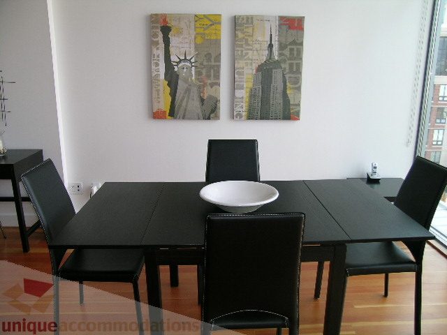 Furnished dining area with black chairs and a modern cityscape painting on the wall. - 902 - 528 Beatty Street, Vancouver Downtown