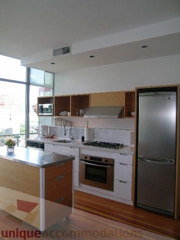 Bright kitchen with stainless steel appliances, hardwood floors, and a city view. - 902 - 528 Beatty Street, Vancouver Downtown