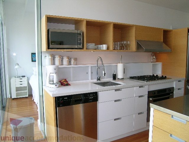 Bright kitchen with white cabinetry, stainless steel appliances, and hardwood floors. - 902 - 528 Beatty Street, Vancouver Downtown