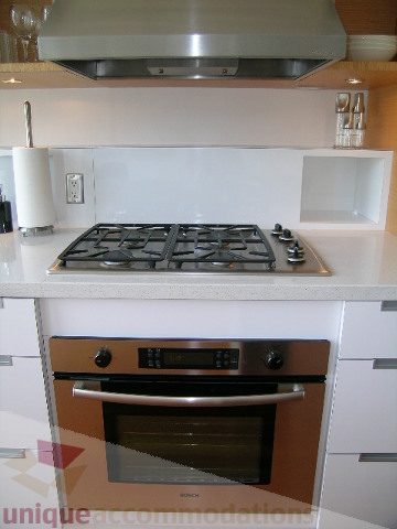 Bright kitchen with modern gas stove, white countertops, and sleek cabinetry. - 902 - 528 Beatty Street, Vancouver Downtown