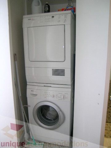 Bright laundry room with stacked washer and dryer, white walls. - 902 - 528 Beatty Street, Vancouver Downtown
