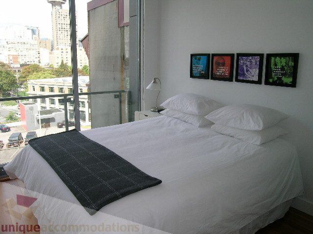 Bright bedroom with two twin beds, white linens, and a city view from the window. - 902 - 528 Beatty Street, Vancouver Downtown