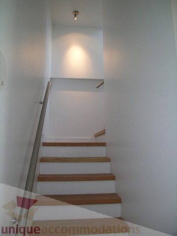 Furnished 1-bedroom condo with wooden stairs and white walls. - 902 - 528 Beatty Street, Vancouver Downtown
