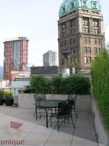 Furnished patio with city view and greenery, overlooking historic architecture. - 902 - 528 Beatty Street, Vancouver Downtown