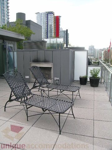 Furnished rooftop patio with city view, modern furniture, and outdoor fireplace. - 902 - 528 Beatty Street, Vancouver Downtown
