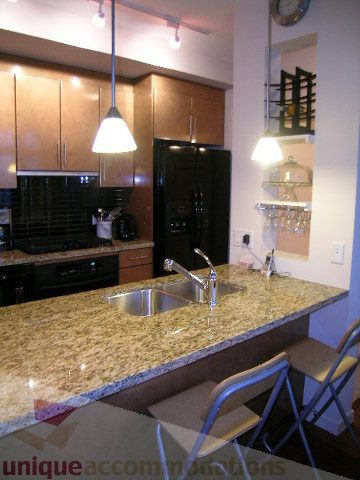 Bright kitchen with granite countertops and modern appliances, showcasing a sleek and contemporary design.