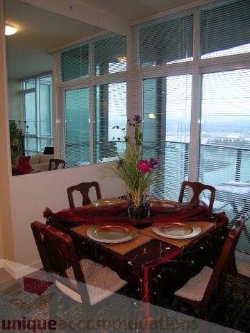 Furnished dining area with city view and modern decor. - 3802 - 1189 Melville Street, Vancouver Downtown