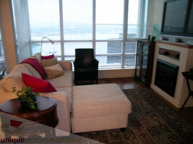 Bright living room with city view, large windows, and modern furniture. - 3802 - 1189 Melville Street, Vancouver Downtown